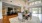 Open resident lounge area with kitchen space, high ceilings, and tables and chairs