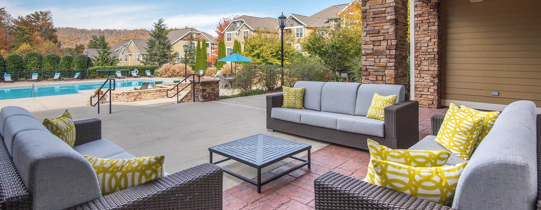 Outdoor seating by clubhouse with view over the pool